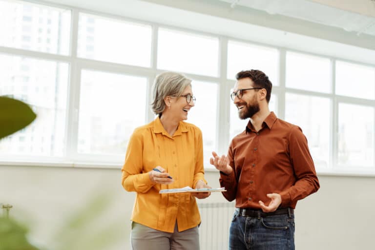 Two coworkers smiling and talking