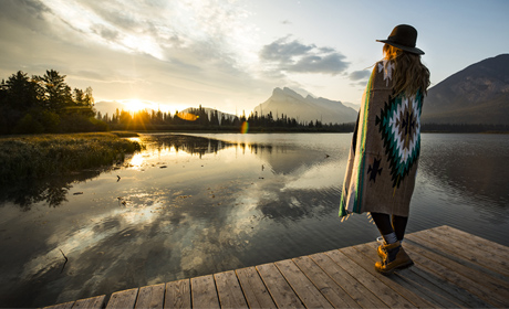 A person standing on a dock looking into a body of water