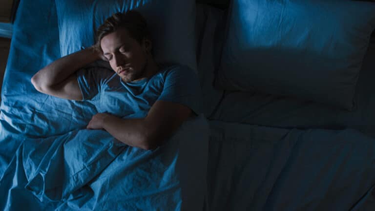 A man sleeping in a bed at night